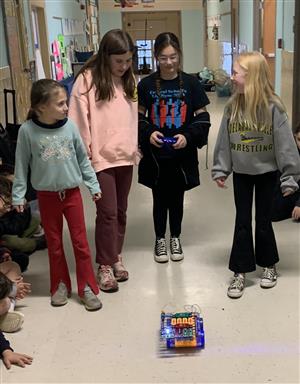 Fourth graders using controls to move their Rover down the hallway.