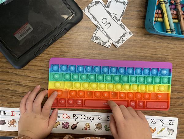 Using a Pop-It keyboard to learn to type in our sight words.